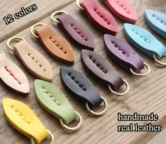 several different colors of leather clips on a wooden surface with text overlay that reads 12 colors handmade real leather