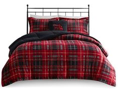 a bed with red and black plaid comforter