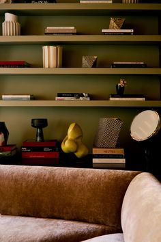 a living room filled with lots of furniture and bookshelf above it's head