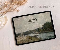 an old oak prints calendar on a table next to flowers and a vase with white flowers