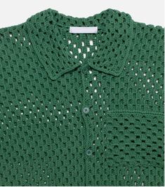 a green crocheted shirt with holes on the chest and collar, in front of a white background