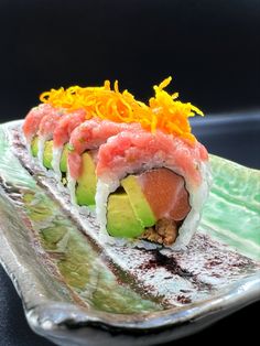 a sushi dish with cucumber, avocado and mustard on it