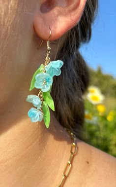 a close up of a person wearing some kind of earring with flowers on it