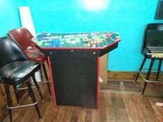 two chairs and a table with a game on it in front of a blue wall