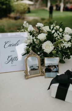 a table topped with white flowers and pictures