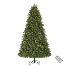 a christmas tree with lights and a remote control on the base, in front of a white background