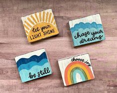 four wooden magnets with different sayings on them sitting on top of a table