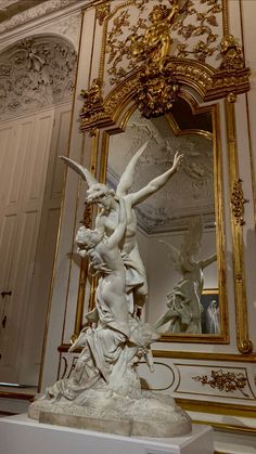 a statue in front of a mirror with gold trimmings on the walls and ceiling