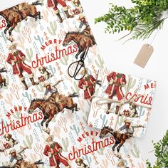 christmas wrapping paper with cowboy images on it and cactus branches in the background, along with an ornament that says merry christmas