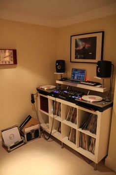 a room with a desk, speakers and laptop on it