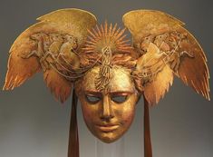 a golden mask with wings on it's head