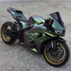 a shiny green motorcycle parked on top of a parking lot