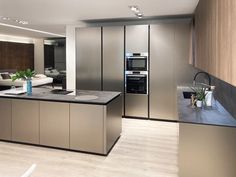 a modern kitchen with stainless steel appliances and wood flooring is pictured in this image