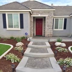 a house with landscaping and steps leading to the front door