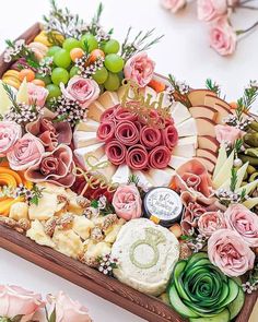 a wooden box filled with lots of different types of food and flowers on top of it