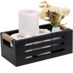 a black wooden box with toilet paper and flowers in it