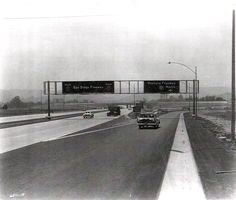 black and white photograph of cars driving on an interstate