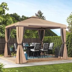 an outdoor gazebo with curtains and chairs around it