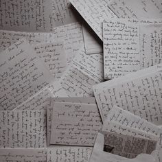 many old letters are piled on top of each other with writing all over the place