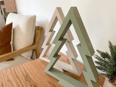 a wooden table topped with a green and white sculpture next to a pillow on top of a chair