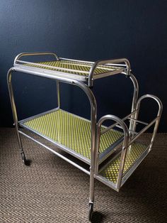 a metal rolling cart with yellow and black checkered flooring on the bottom half