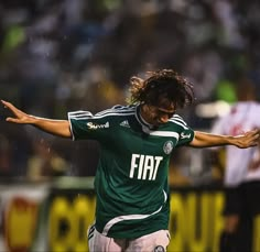 a soccer player in action on the field with his arms stretched out and hands outstretched