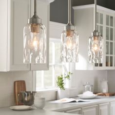 three lights hanging over a kitchen counter top