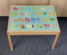 a child's wooden table with letters and numbers on it