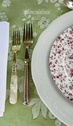 an empty plate and silverware are sitting on a tablecloth with floral print napkins