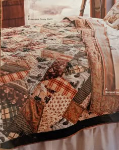 an old quilt is displayed on the cover of a bed with it's comforter