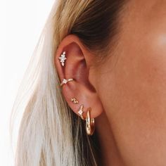 a woman wearing gold ear cuffs with small diamonds