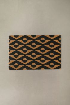 an orange and black area rug sitting on top of a white floor next to a wall