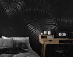 a bedroom with black palm leaves on the wall and a desk in front of it