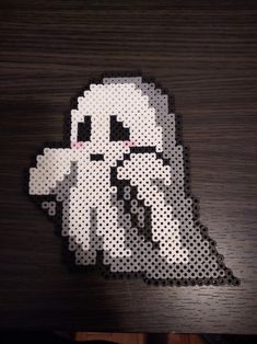 an image of a pixellated sticker on top of a wooden table with the face of darth vader