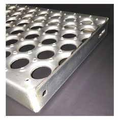 a metal grate with holes in the middle