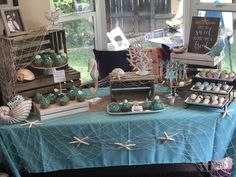 the table is set up with cupcakes and desserts for an ocean themed party