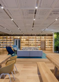 the interior of a modern office with wooden flooring and built in bookshelves