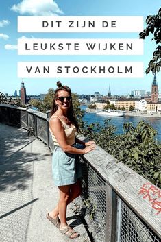 a woman standing on top of a bridge next to the water