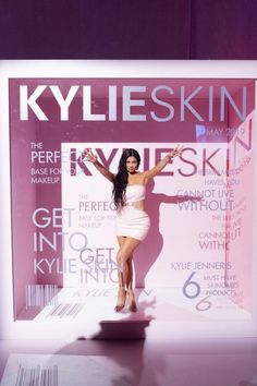 a woman standing in front of a display window with her arms up and hands out