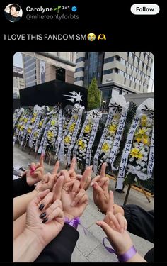 several people are holding their hands up in the air with flowers and ribbons around them