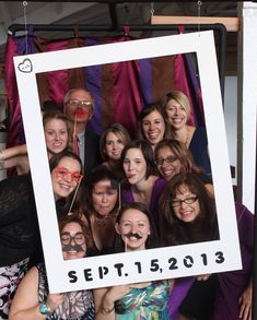 a group of people posing in front of a photo booth with their faces painted like mustaches