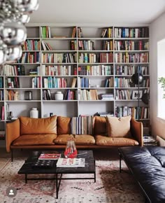 a living room filled with lots of furniture and bookshelves covered in shelves full of books