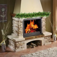 a fireplace with flowers on the mantle and fire in the middle, surrounded by rugs