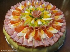 a cake decorated with fruit and flowers on top of a wooden table