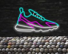 a neon shoe on top of a pile of rocks in front of a brick wall