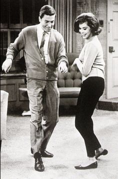 an old black and white photo of a man and woman dancing in a living room