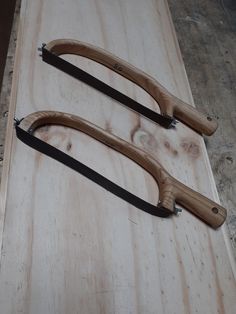 two pairs of scissors sitting on top of a piece of wood