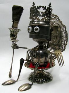 a robot holding a fork and knife in it's right hand while wearing a crown