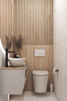 a white toilet sitting next to a sink under a bathroom faucet in front of a wooden paneled wall