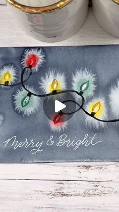 a merry and bright doormat with lights on it next to two cans filled with candles